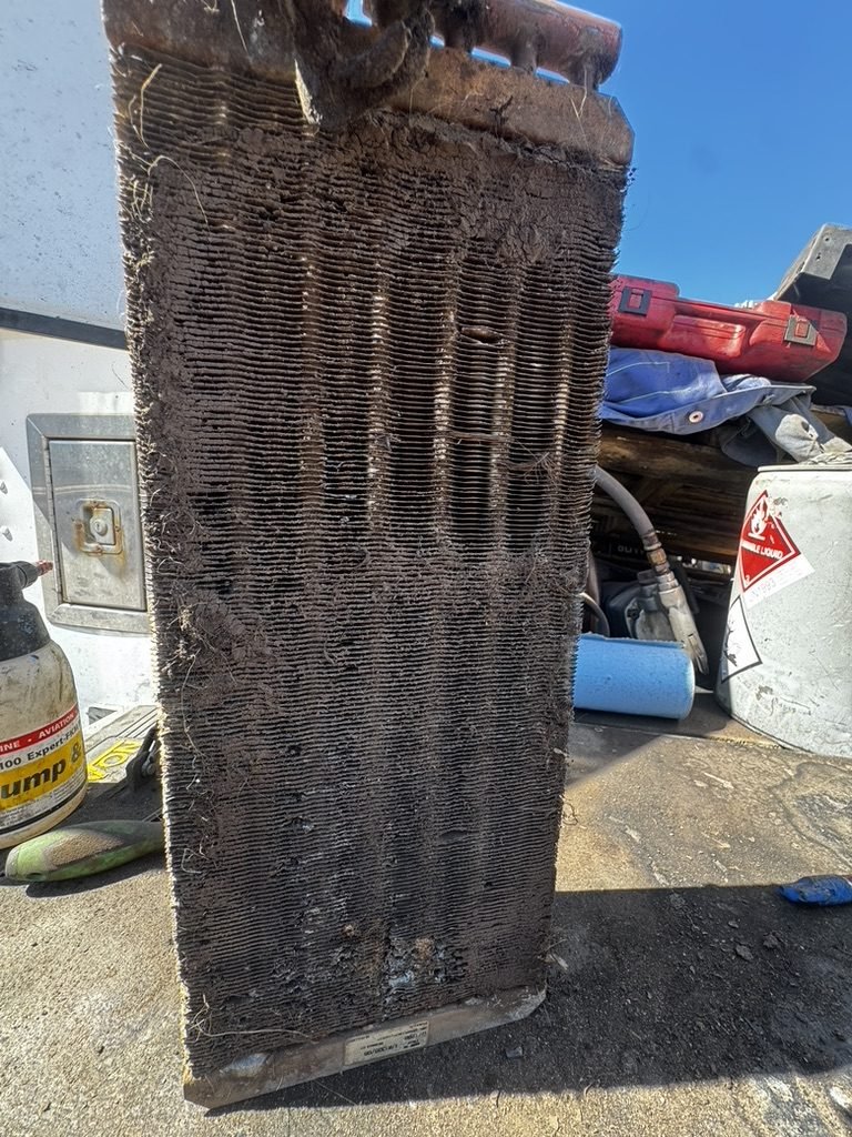 Radiator core packed solid with mud and debris, blocking airflow